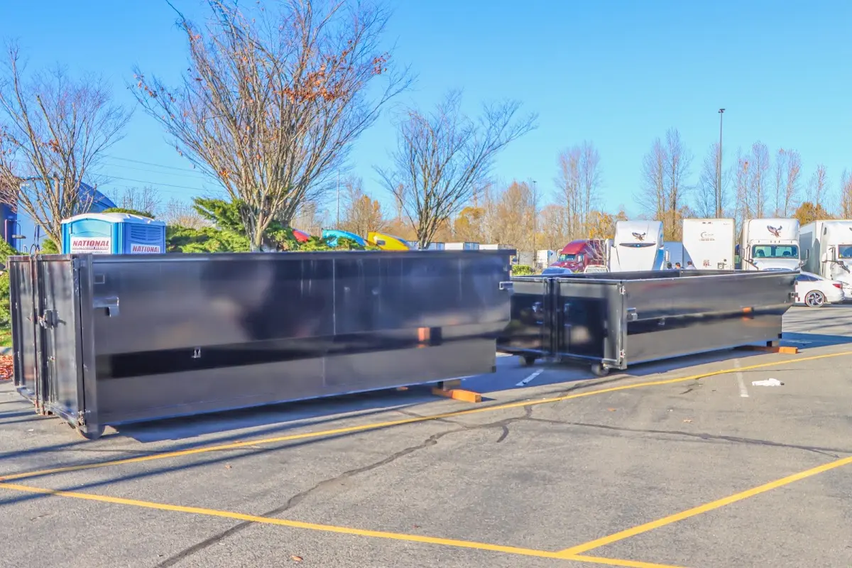 Professional dumpster rental service with roll-off container on residential driveway in Lower